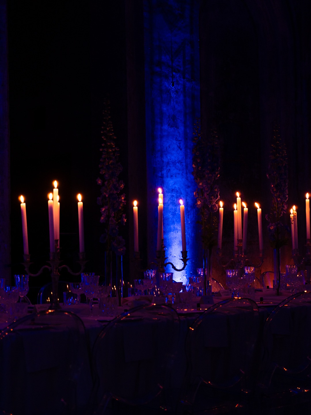 Cena di gala con candelabri accesi e luce blu scenografica